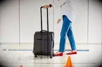 A person walking with the Calpak Luka Soft-Sided Carry-On Luggage on a rug