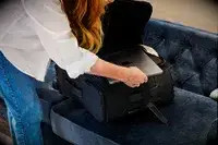 A person placing a laptop into the Calpak Luka Soft-Sided Carry-On Luggage