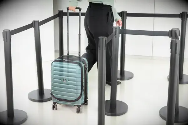 A person wheels the Delsey Paris Shadow 5.0 Carry-on with Laptop Compartment through line markers