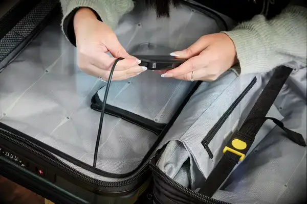 A person adjusts the lock on the Delsey Paris Shadow 5.0 Carry-on with Laptop Compartment