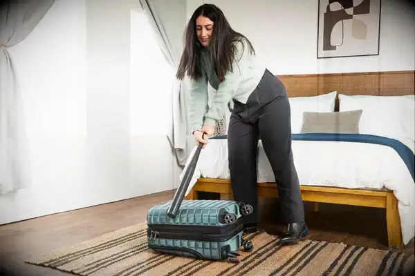 A person hits the Delsey Paris Shadow 5.0 Carry-on with Laptop Compartment with a baseball bat