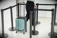 A person wheels the Delsey Paris Shadow 5.0 Carry-on with Laptop Compartment through line markers