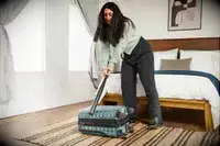 A person hits the Delsey Paris Shadow 5.0 Carry-on with Laptop Compartment with a baseball bat