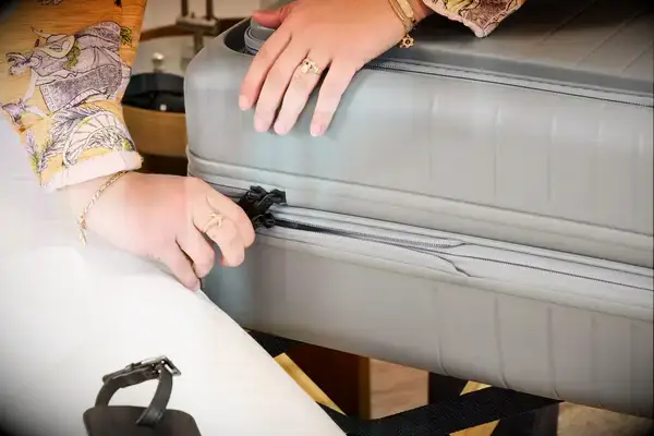 A person closes the Monos Expandable Carry-on Pro