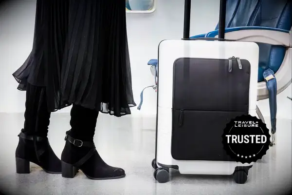 Passenger rolling July Carry On Pro SnapSleeve near airplane seats