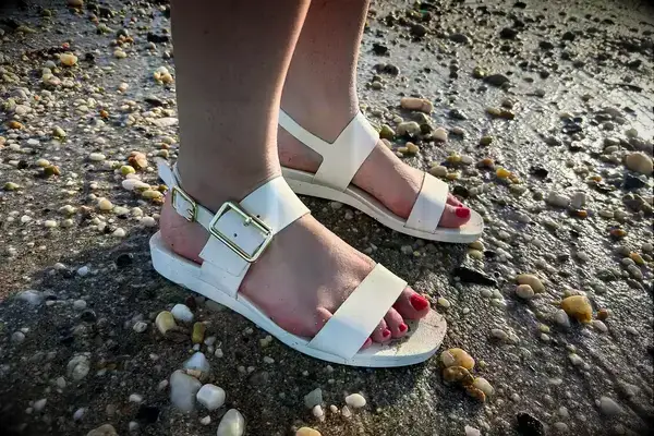 Side view of a person wearing the Bared Footwear Sanderlings on the sand