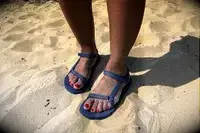 A person wearing the Teva Original Universal Slim Sandal in the sand