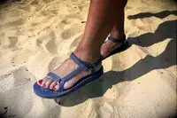 A person wearing the Teva Original Universal Slim Sandal in sand