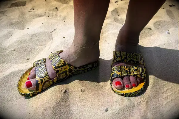 A person wearing Freedom Moses Freedom Slides in sand
