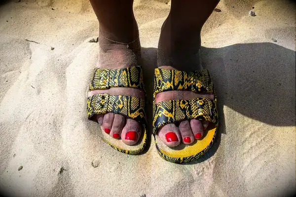 a person wearing Freedom Moses Freedom Slides in the sand