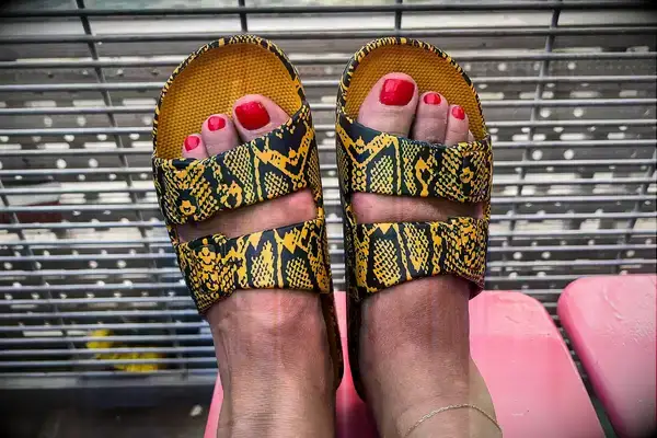 A persons feet wearing the Freedom Moses Freedom Slides