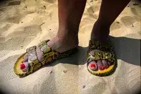 A person wearing Freedom Moses Freedom Slides in sand