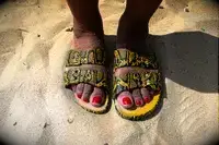 a person wearing Freedom Moses Freedom Slides in the sand