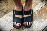 Top view of a person wearing the Franco Sarto Taziana Espadrille Slide Sandals on a wood background