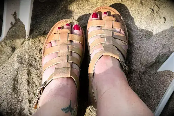 A person wearing the Bear Paw High Seas Iced Coffee Sandals in the sand