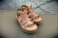 Bear Paw High Seas Iced Coffee Sandals on the sand with water creeping onto shore