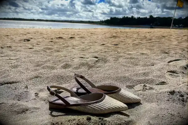 Marion Parke Patty Slingback Sandals on the sand with water in the background