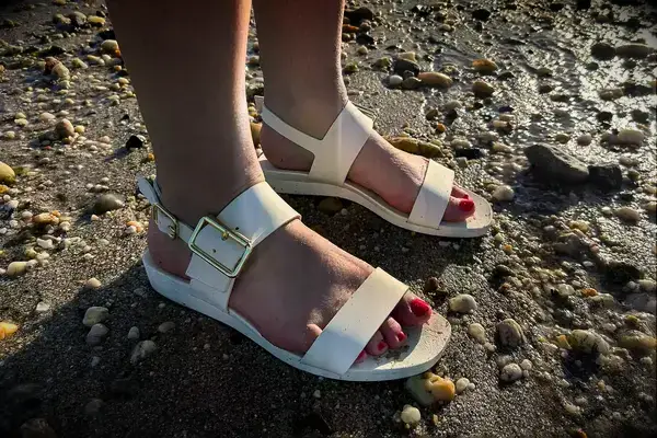 Side view a person wearing the Bared Footwear Sanderlings on the sand