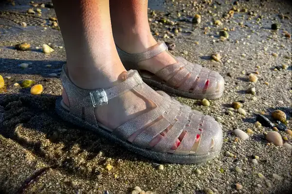 Side view of a person wearing the Melissa Possession Jelly Fisherman Sandal on the sand