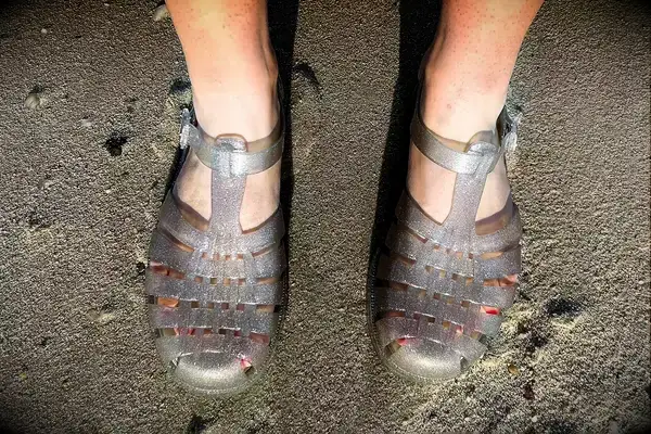 A person wearing the Melissa Possession Jelly Fisherman Sandal on the sand