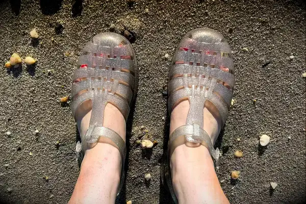 A person wearing the Melissa Possession Jelly Fisherman Sandal on the sand
