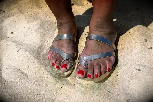 Close up of a person wearing the Frankie4 Isla on the sand