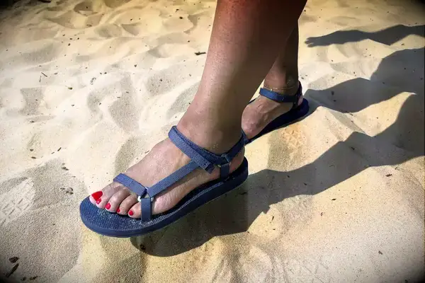 A person wearing the Teva Original Universal Slim Sandal in sand