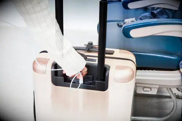 Hand plugging a USB cord into the July Carry On