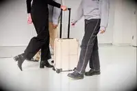 Person rolling the July Carry On through other people