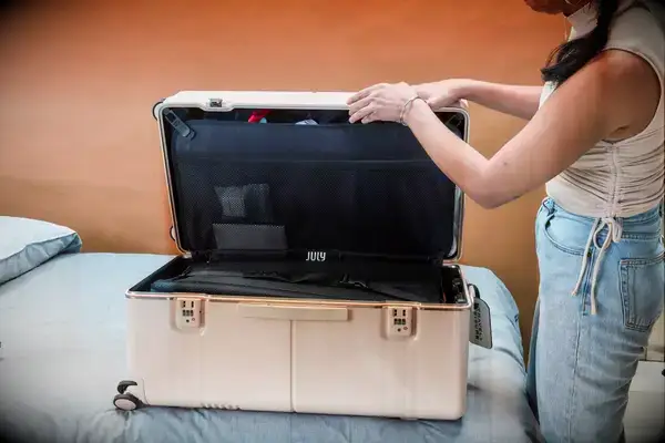 A person closing a trunk from the July Trunk Set