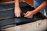 Hands clipping the strap inside a trunk from the July Trunk Set