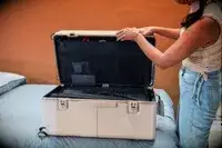 A person closing a trunk from the July Trunk Set