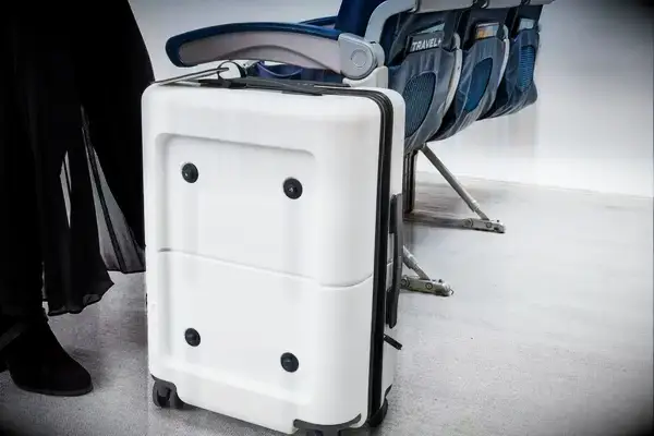 Person standing near July Carry On Pro SnapSleeve alongside airplane seats