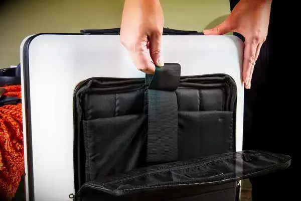 Hands open the sleeve on a July Carry On Pro SnapSleeve
