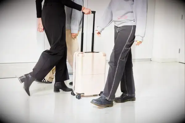 Person rolling the July Carry On through other people