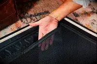 Hand inside a mesh pocket inside the July Checked Plus Large Luggage