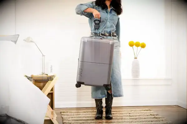 A person weighs the July Carry-on Max