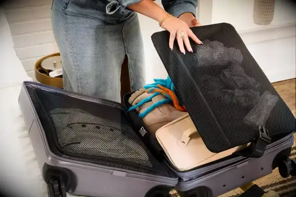 A person unpacks the July Carry-on Max
