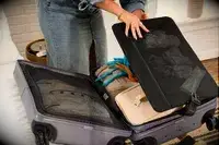 A person unpacks the July Carry-on Max
