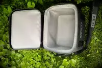 A Yeti Hopper Flip 12 Soft Cooler sits in foliage with its lid open