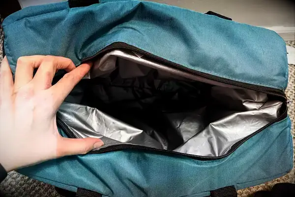 A person holds the Igloo Latitude Snapdown 36-Can Cooler Bag open