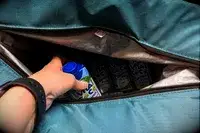 A person places a drink into the Igloo Latitude Snapdown 36-Can Cooler Bag