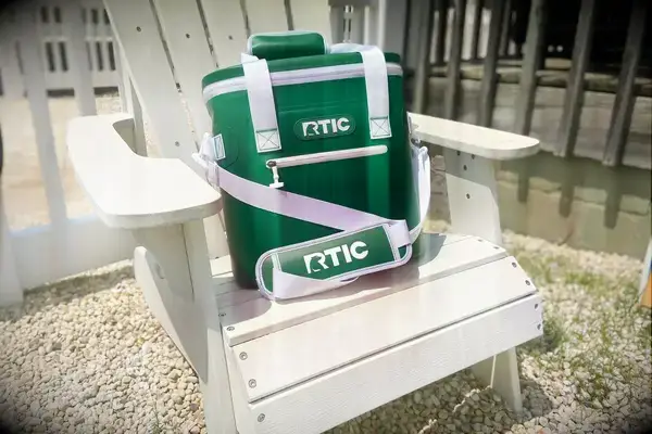 The RTIC Insulated Soft Cooler Bag displayed on a chair outdoors