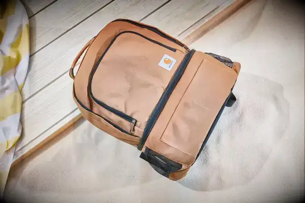 Carhartt 2-in-1 Insulated Cooler Backpack displayed on sand