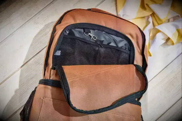 Carhartt 2-in-1 Insulated Cooler Backpack displayed on wood surface with open front pocket