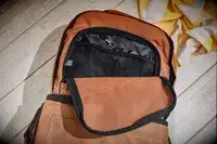Carhartt 2-in-1 Insulated Cooler Backpack displayed on wood surface with open front pocket