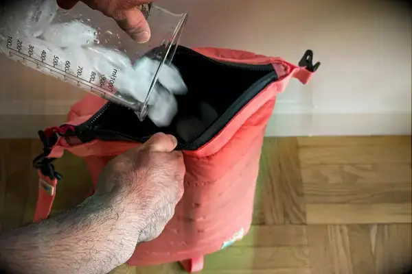 A person pours ice into the Monti The Mayfly 14L Cooler