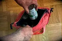 A person places a can into the Monti The Mayfly 14L Cooler