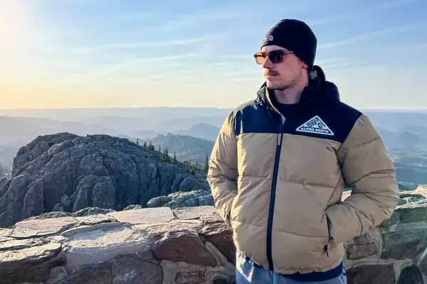 Man standing in Alpine North TukTut Jacket with mountains in the backdrop