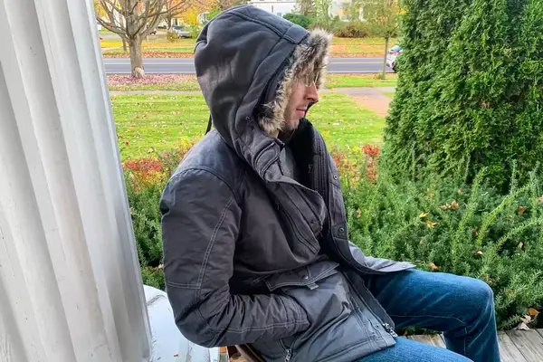 A person sits outside while wearing the Kuhl Men